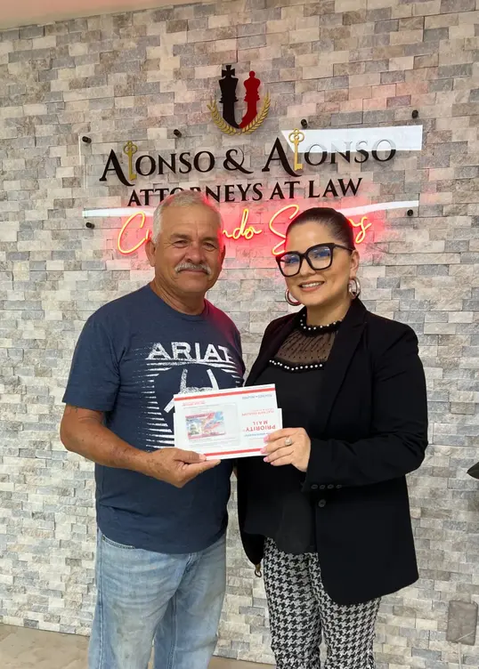 Pareja latina con sus tarjetas de residencia.