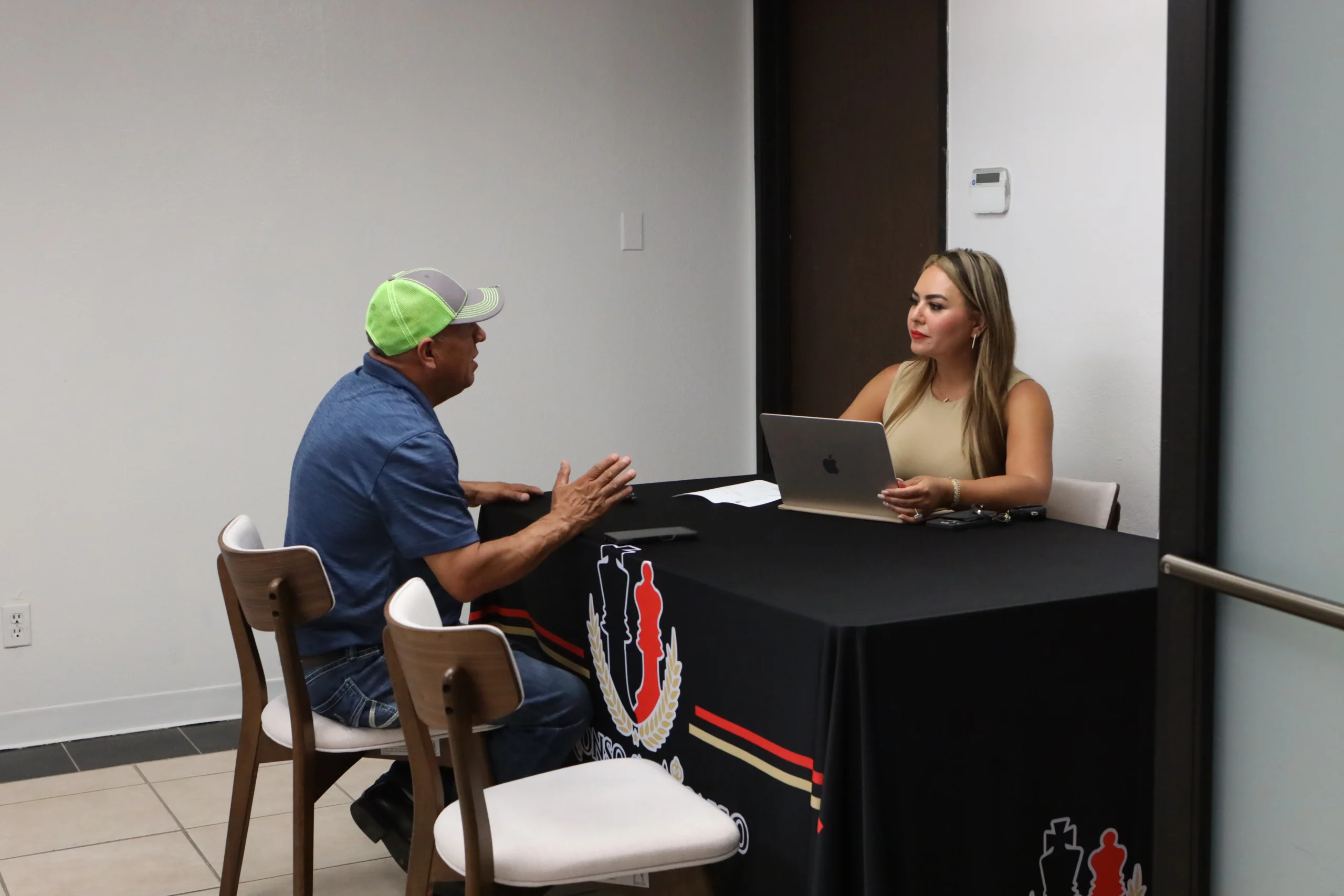 Consulta con abogado de inmigración en Dallas entre equipo legal y cliente en oficina.