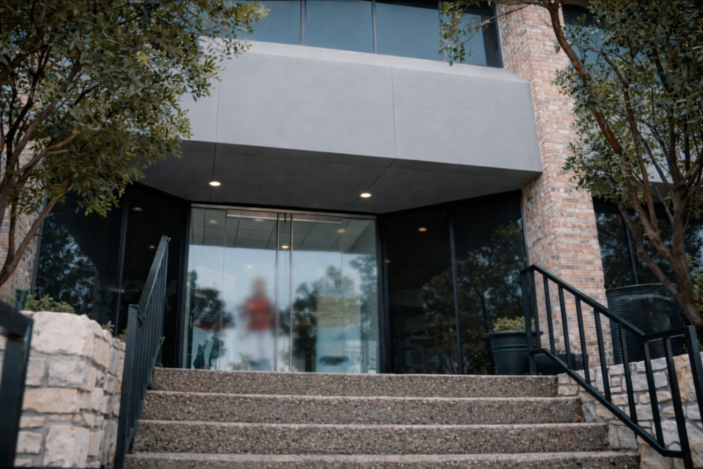 Exterior entrance of Alonso & Alonso immigration law office in Austin Texas showing modern office building and front stairs.