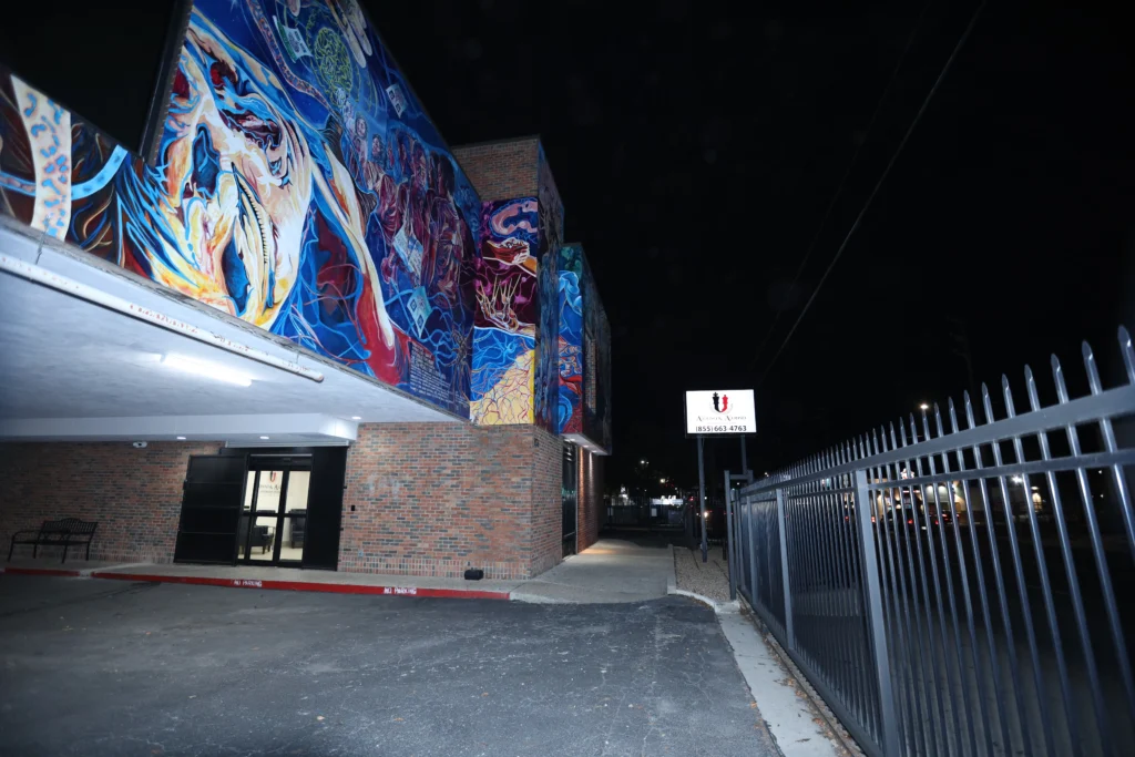 Exterior de oficina de abogados de inmigración en San Antonio TX con mural durante la noche